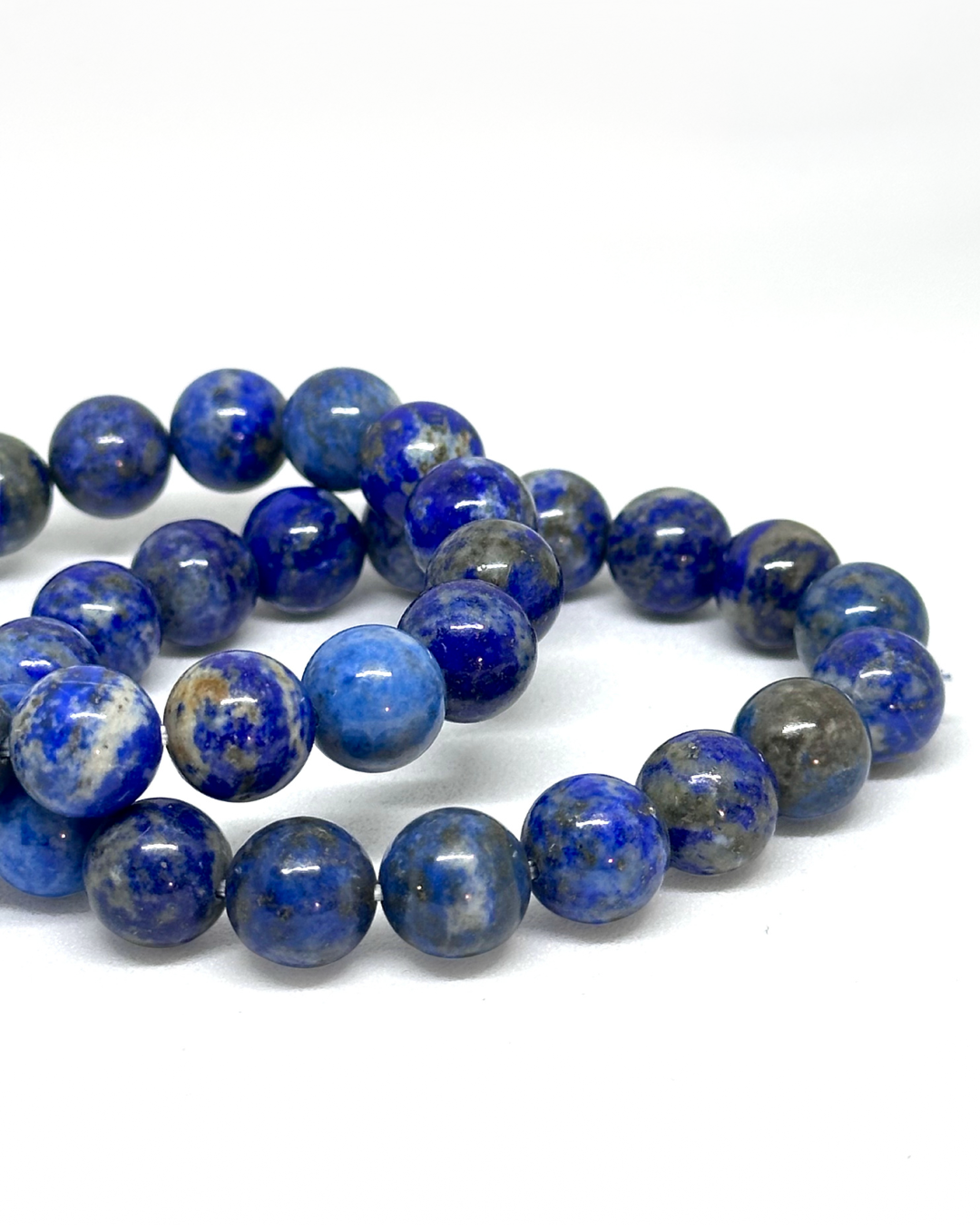String of blue and gray Lapis beads on a white background