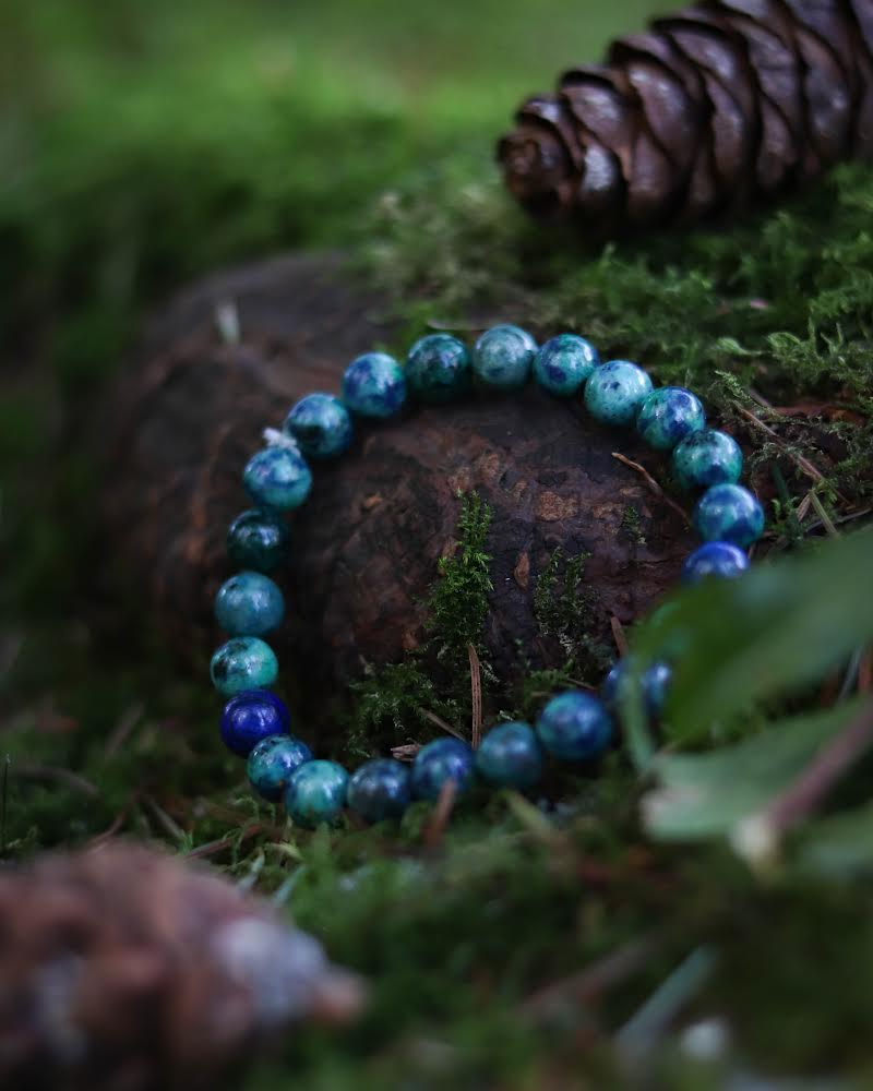 Blue beaded Azurite bracelet on a wooden surface with moss and pine cones